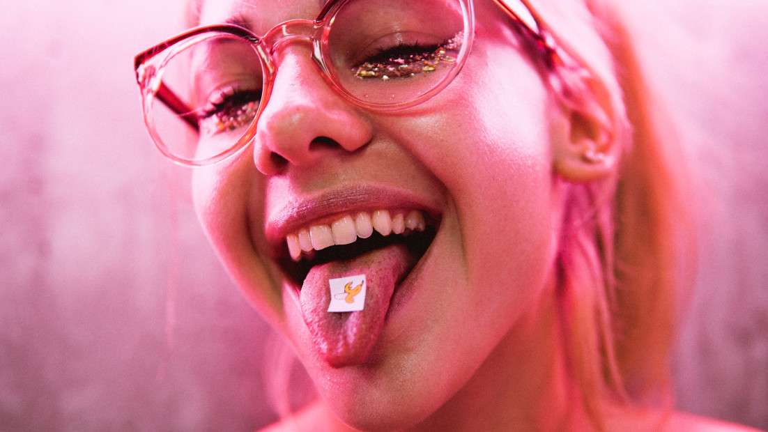 Girl teenager at a music festival taking LSD acid